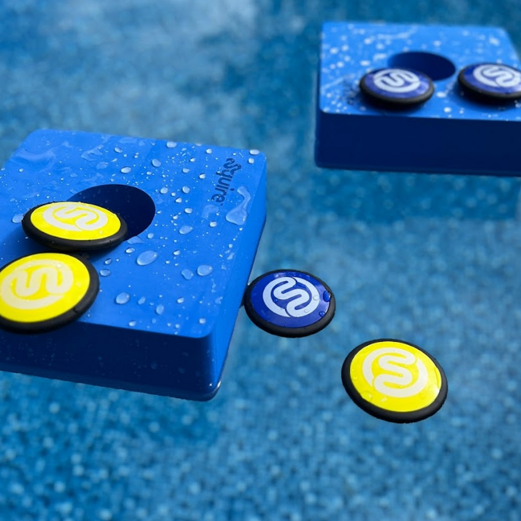 2 original Squire above-ground pool game targets floating in clear blue pool with 6 skip discs